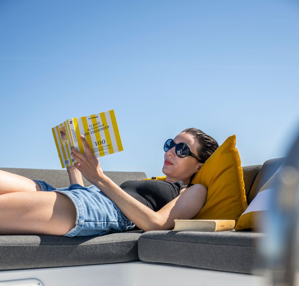 mulher lendo um livro a bordo de um catamaran lagoon